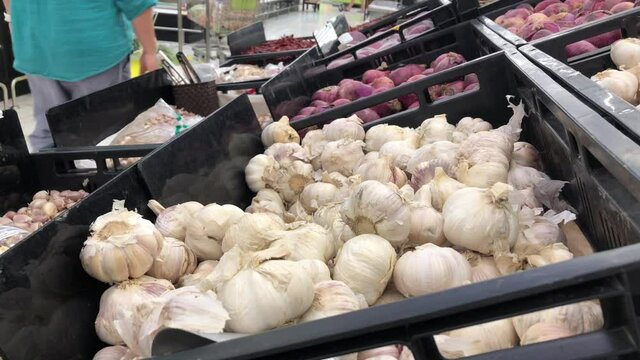 Customer selecting garlic in the market