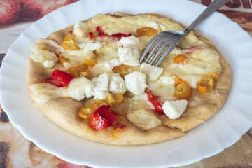 Homemade pizza with yellow and red tomatoes