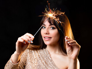 Obraz premium birthday or New Year's eve party. Young beautiful brunette in a gold dress