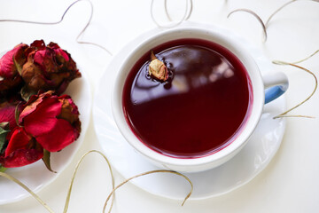 white cup with flower tea and frame of dried flowers, leaves and branches 
