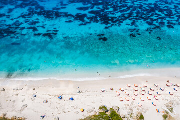 Aerial top down drone photo of Petani beach with beautiful turquoise sea and summer sunbeds, Cefalonia island, Ionian, Greece