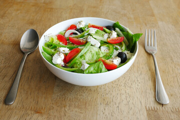 Close up of greek salad in a bowl on table.