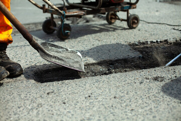 Shovel with asphalt. Repair of the road. Tool for cleaning old asphalt.