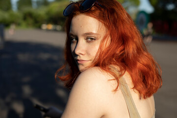 Fototapeta premium The girl looks dreamy. Red-haired beauty. Teenager in t-shirt.