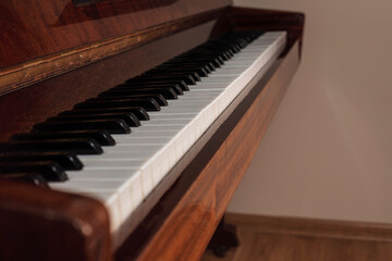Keys of an old wooden piano, side view, nobody plays the piano because it's a vacation, children are resting