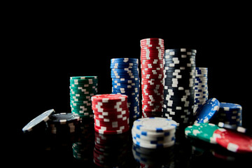 Stack of Casino gambling chips isolated on black reflective background