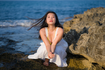 young happy and beautiful Asian woman by the sea - Attractive Japanese girl in white dress enjoying relaxed summer holidays at tropical island in travel and lifestyle concept