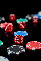 Background made of Casino chips and dices on dark reflective background with copy space