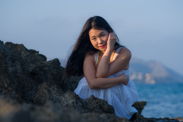 young happy and beautiful Asian woman by the sea - Attractive Korean girl in white dress enjoying relaxed summer holidays at tropical island in travel and lifestyle concept