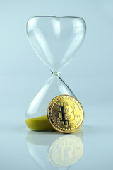Bitcoin coin with an hourglass. The rapid growth of the cryptocurrency.