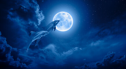 Silhoutte of dolphins jumping up from the sea with blue full moon "Elements of this image furnished by NASA " © muratart