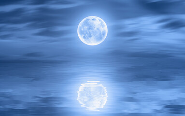 Night sky with moon in the clouds on the foreground calm sea"Elements of this image furnished by NASA