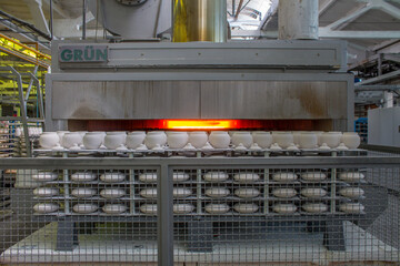 New ceramic identical white pots sent to a muffle kiln for firing at a porcelain factory in the...