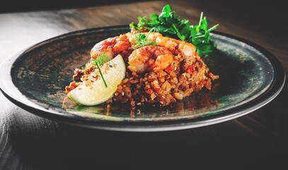 Fried rice with shrimp and vegetables in plate on wooden table background