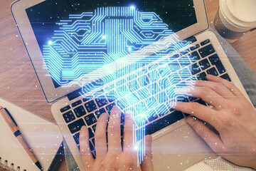 Double exposure of man's hands typing over computer keyboard and brain hologram drawing. Top view. Ai and data technology concept.