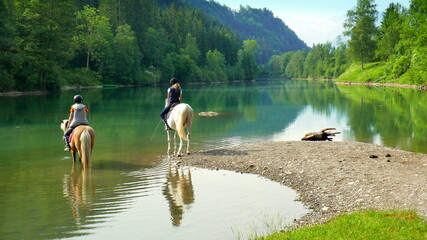 idyllischer Auwaldsee bei Fischen im Allgäu mit Wald und 2 Reitern am See in malerischer Landschaft