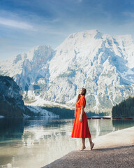 Lago di Braies. Beautiful girl in a red dress on the lake Braies (Lago di Braies) in Dolomites Mountains. Boats on the Braies Lake ( Pragser Wildsee ) in Dolomites mountains, Sudtirol, Italy