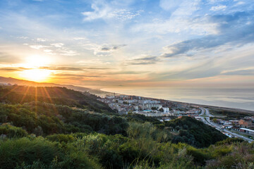 View from the mountain of a Mediterranean village near the Mediterranean at sunset, a white Mediterranean city with the sea and sunset.