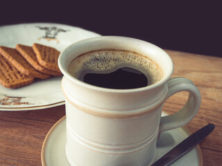 Cup of coffee and cookies on the table, blurred background