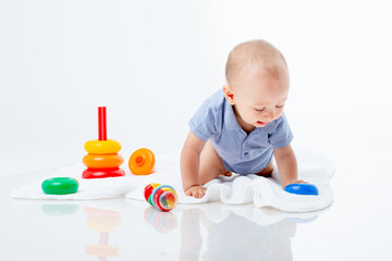 baby boy with a multi-colored pyramid is isolated on a white background;
