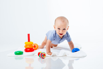 baby boy with a multi-colored pyramid is isolated on a white background;