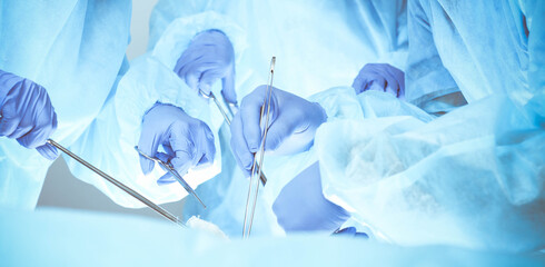 A group of surgeons is operating at the hospital, close-up of hands. Health care concept