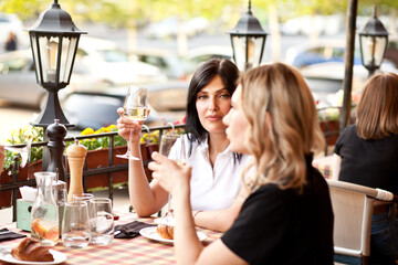 Young women drinking a white wine in a cafe terrace
