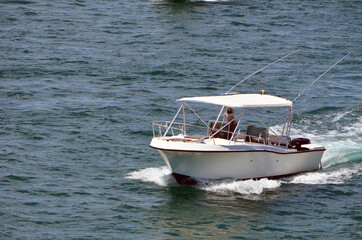 Small white sport fishing boat with white canvas canopy.