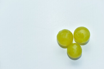 Three green grapes on a white background macro