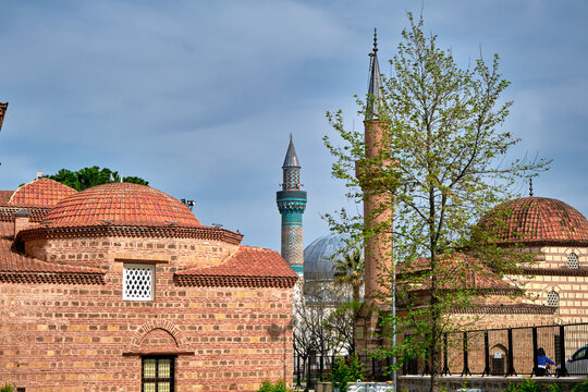Nicaea (iznik), Bursa Turkey.  seyh  kutbuddin and its son tomb made of red bricks wall with its minaret extends to blue cloudy sky with green mosque (yesil cami) background. 17.04.2021. iznik turkey.