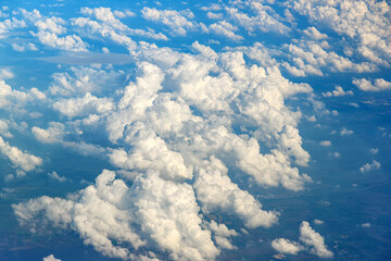 Clouds against blue sky view through an airplane window for a background.