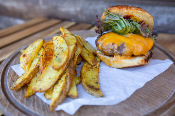 Tasty hamburger with french fries on the table.