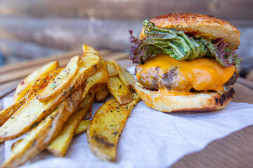 Tasty hamburger with french fries on the table.