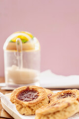 Neutral view some homemade butter cookies with jam, in the background you can see a sugar bowl out of focus. Homemade and natural food concept. Vertical orientation. Copy space.