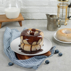 Donuts with chocolate topping on table with milk