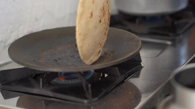 Closeup shot of hands of an Indian female making roti in the kitchen