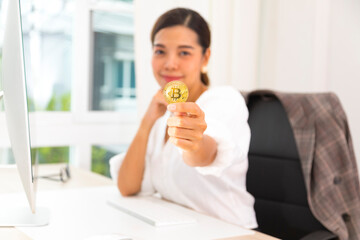 Asian businesswoman holding gold bitcoin, blockchain and bitcoin concept.