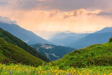 Green mountain peaks. Layers of mountains in the haze during sunset. Multilayered misty nountains. Krasnaya Polyana, Sochi, Russia.
