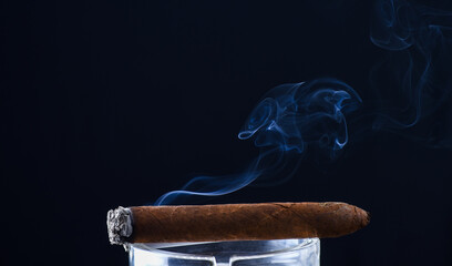 Steaming cuban cigar with smoke puff dark background, copy space, smoking