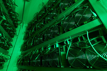 Bitcoin miners in large farm. ASIC mining equipment on stand racks mine cryptocurrency in steel...