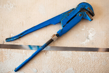 Close-up of adjustable gas wrenches of blue color on wooden table.