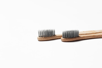 Close-up of two bamboo toothbrushes on white background.