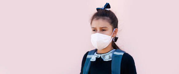 Panoramic banner of school girl wearing medical mask, on pink background.