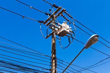 power utility pole with transformers and street light.