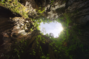 awesome deep cave in kuala lumpur - malaysia.  ground of a hole with falling light spots.