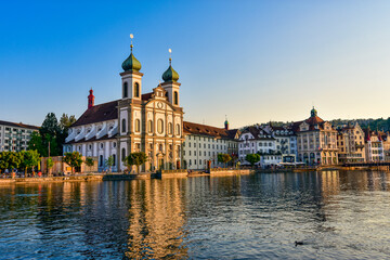 Beautiful view of Lucerne historic city center with Jesuit Church (Jesuitenkirche in German) and river Reuss on a sunset sky. Lucerne, Switzerland