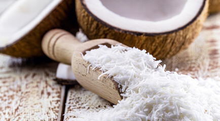 Vintage wooden spoon, grated coconut, shavings and coconut flakes, culinary ingredient for sweets and desserts