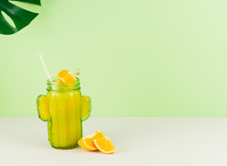 Cactus-shaped glass with orange juice. Copy space.
