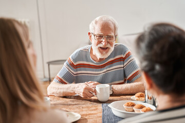Senior man laughing out loud while speaking with his friends at the retirement house