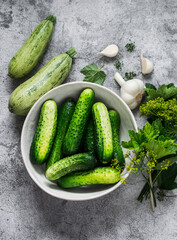 Ingredients for canning cucumbers and zucchini on a gray background, top view